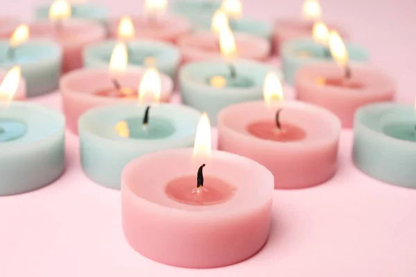Vypalování barevných ozdobných svíček na růžovém pozadí, prostor pro text — Stock fotografie