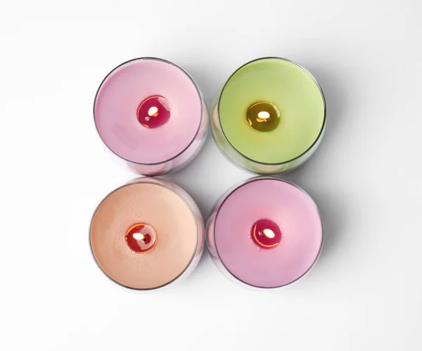 Bougies en cire de couleur dans des porte-verre isolés sur blanc, vue de dessus — Photo