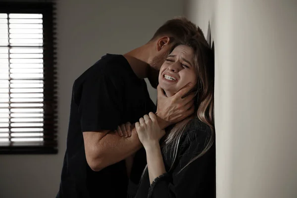 Man choking young woman indoors. Stop sexual assault — Stock Photo, Image