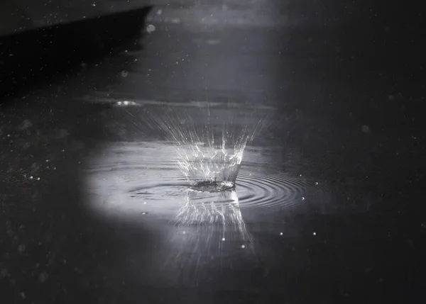 Salpicadura de agua sobre fondo oscuro. Clima lluvioso — Foto de Stock