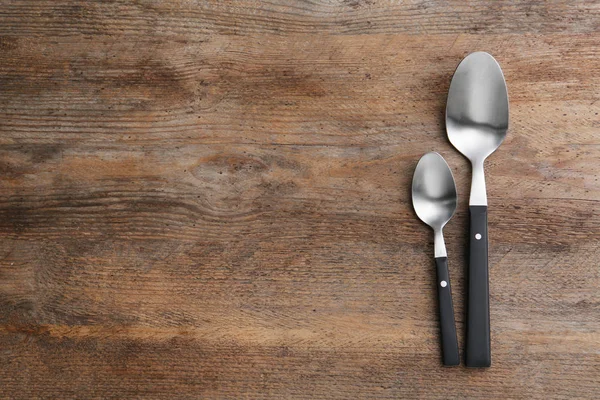 Clean empty table spoons on wooden background, top view. Space for text — Stock Photo, Image