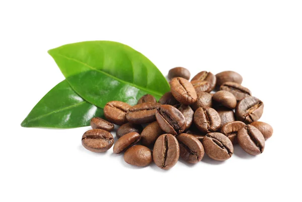 Granos de café tostados y hojas verdes frescas sobre fondo blanco —  Fotos de Stock