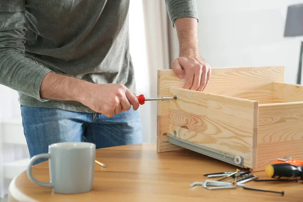 Ung arbetande man reparera låda hemma, närbild — Stockfoto