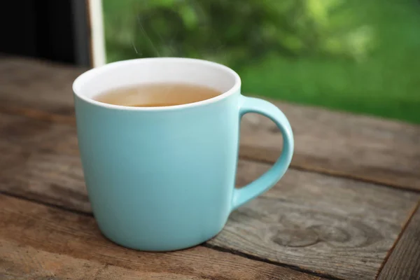 Xícara de chá quente na mesa de madeira — Fotografia de Stock