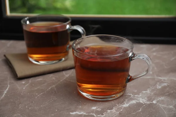 Tasses de thé chaud sur le rebord de la fenêtre en marbre gris — Photo