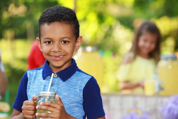 Lindo niño afroamericano con limonada natural en el parque, espacio para el texto. Bebida refrescante de verano — Foto de Stock