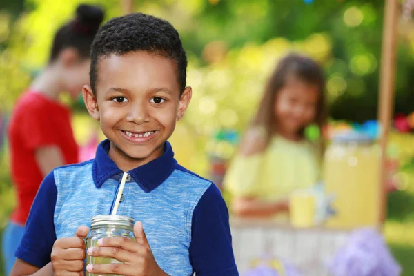 Lindo niño afroamericano con limonada natural en el parque, espacio para el texto. Bebida refrescante de verano — Foto de Stock