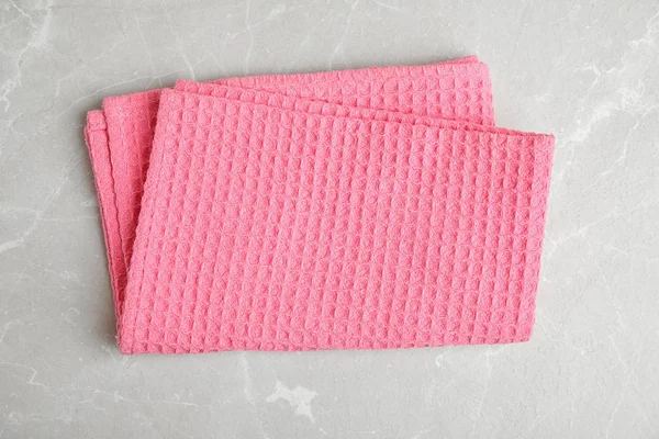 Рожевий кухонний рушник на світлому мармуровому фоні, вид зверху — стокове фото