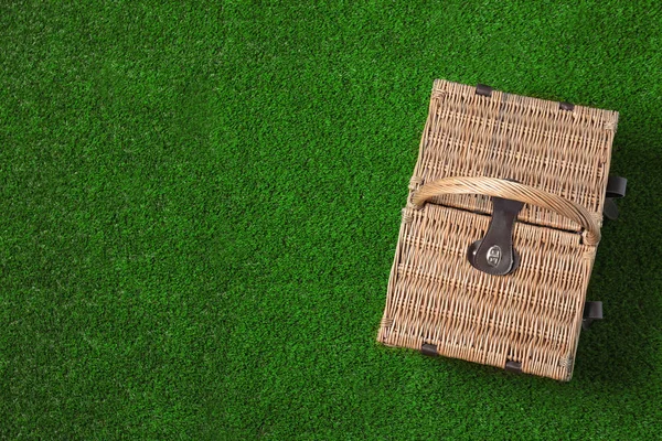 緑の草、トップビュー上の閉鎖されたウィッカーピクニックバスケット。テキスト用のスペース — ストック写真