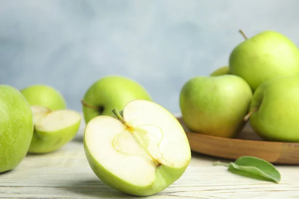 Pommes vertes mûres fraîches sur table en bois sur fond bleu, espace pour le texte — Photo