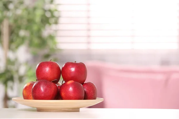 Plate with sweet red apples on table in room, space for text — Stock Photo, Image