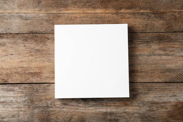 Stack of blank paper sheets for brochure on wooden background, top view. Mock up — Stock Photo, Image