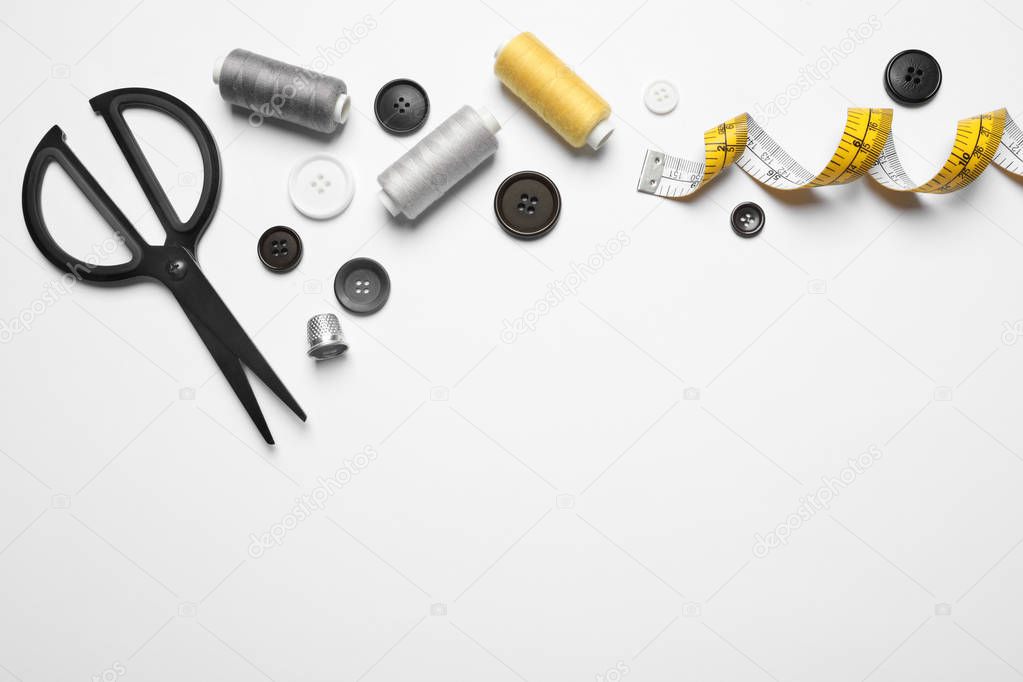 Composition with scissors and other sewing accessories on white background, top view