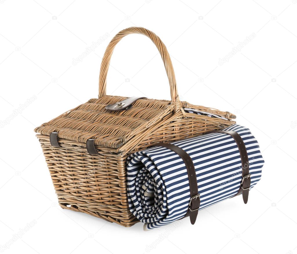 Closed wicker picnic basket with blanket on white background