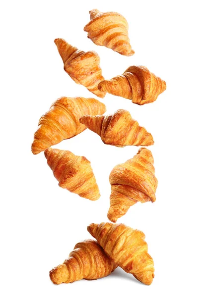 Caduta deliziosi croissant appena sfornati su sfondo bianco. Pasticceria francese — Foto Stock