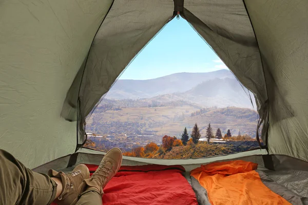 Closeup of woman in camping tent with sleeping bags on mountain hill, view from inside — Stock Photo, Image