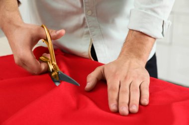 Profesyonel terzi kesme kırmızı kumaş içinde makas ile atölye, çekim