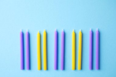 Açık mavi arka planda renkli Doğum günü mumlar, düz yatıyordu