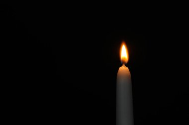 Karanlık arka planda yanan mum, metin için alan. Keder sembolü