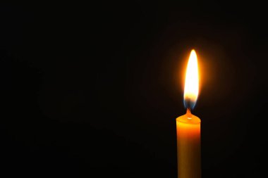 Karanlık arka planda yanan mum, metin için alan. Keder sembolü