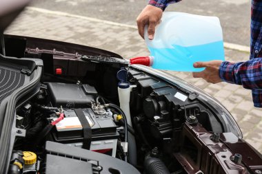 Adam araba yıkayıcı sıvı rezervuarı içine plastik teneke kutu sıvı dökme, çekim