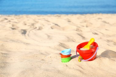 Deniz yakınında kum üzerinde plastik plaj oyuncakları ayarlayın. Metin alanı