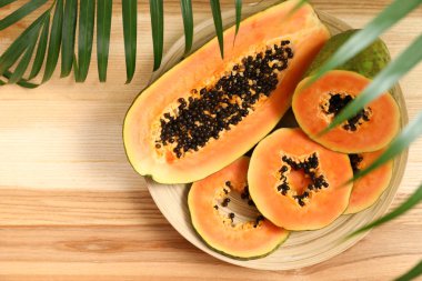 Ahşap masada, üst görünümde kesilmiş Papaya ile plaka. Metin alanı