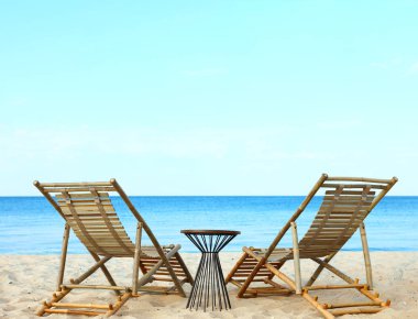 Kumlu sahildeki boş ahşap şezlong ve plaj aksesuarları