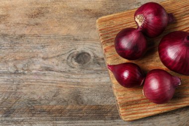Ahşap masa üzerinde kurulu ve olgun kırmızı soğan, metin için boşluk ile üst görünüm