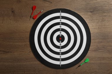 Ahşap arka planda renk okları ile dart tahtası, üst görünüm