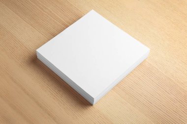 Ahşap arka planda broşür için boş kağıt levha yığını. Sahte