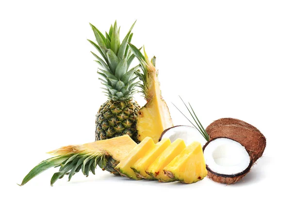 Läckra kokosnötter och mogna saftiga ananas på vit bakgrund — Stockfoto