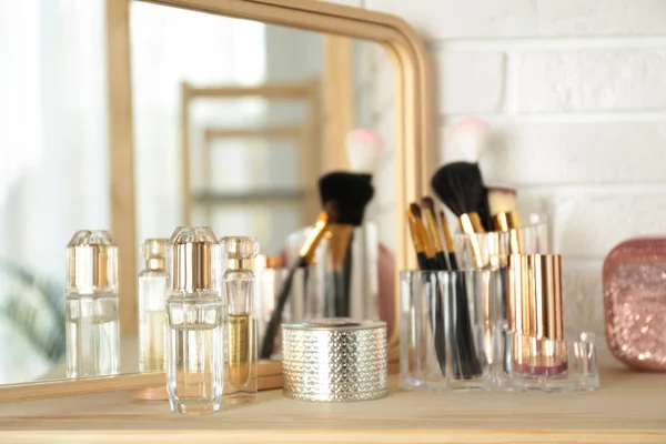 Perfumes and makeup products on dressing table