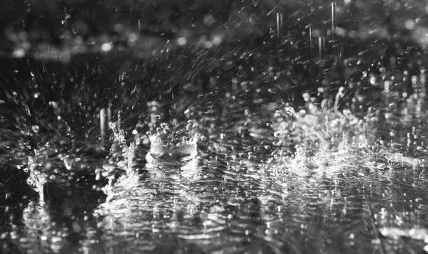 Lluvia fuerte cayendo sobre el suelo sobre fondo oscuro — Foto de Stock