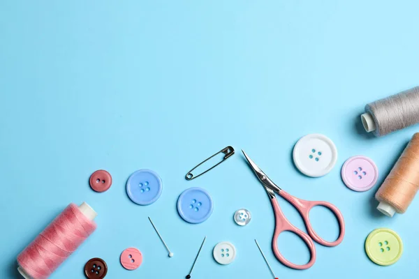 Composición plana con tijeras y otros accesorios de costura sobre fondo azul claro. Espacio para texto — Foto de Stock