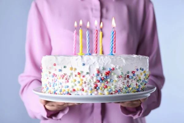 Жінка тримає торт на день народження з палаючими свічками, крупним планом — стокове фото