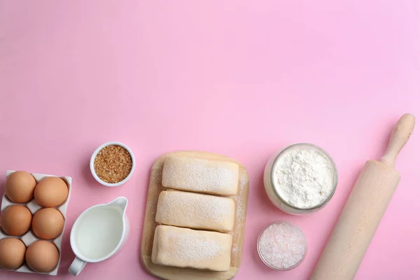 Masa de hojaldre y los ingredientes sobre fondo rosa, la puesta plana. Espacio para texto — Foto de Stock