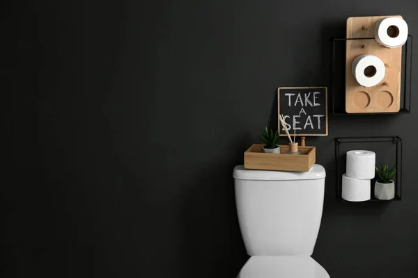 Dekorelemente, Notwendigkeiten und Toilettenschüssel in der Nähe der schwarzen Wand, Platz für Text. Badezimmerausstattung — Stockfoto