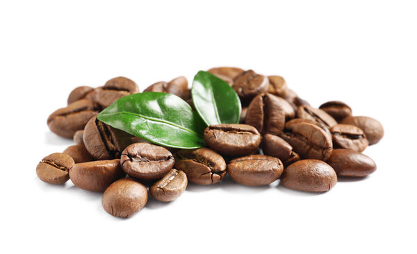 Жареный кофе в зернах и свежие зеленые листья на белом фоне
