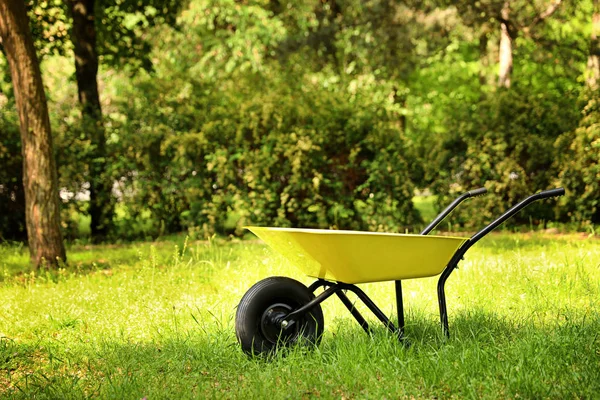 Kruiwagen op gras buiten, ruimte voor tekst. Tuinieren, gereedschap — Stockfoto