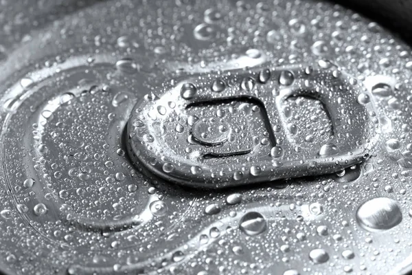 Aluminum can of beverage covered with water drops as background, closeup