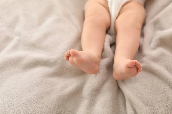 Niedliches kleines Baby auf dem Bett liegend, Nahaufnahme der Beine. Raum für Text — Stockfoto