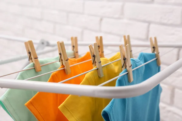 Beda lucu bayi onesies tergantung pada garis pakaian dekat dinding bata. Hari Laundry — Stok Foto