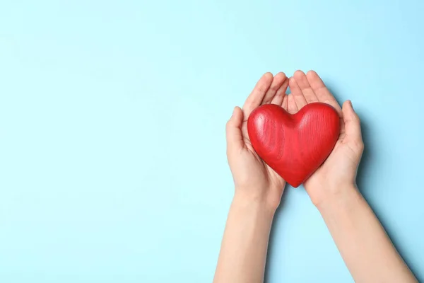 Mujer sosteniendo el corazón sobre fondo azul, vista superior con espacio para el texto. Concepto de donación —  Fotos de Stock