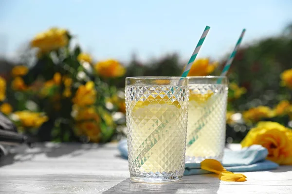 Erfrischende Limonade auf weißem Holztisch im Rosengarten. Raum für Text — Stockfoto