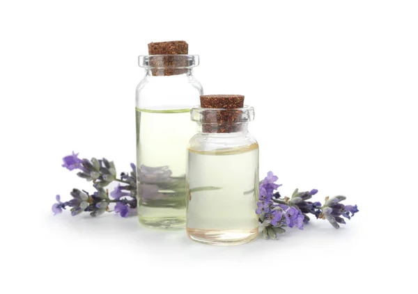 Botellas con aceite de lavanda natural y flores sobre fondo blanco — Foto de Stock