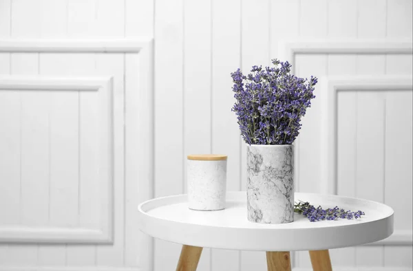 Fresh lavender flowers in vase on table against white wooden background, space for text