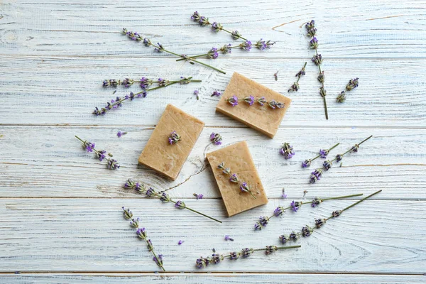 Composizione flat lay di saponette fatte a mano con fiori di lavanda su sfondo di legno bianco — Foto Stock