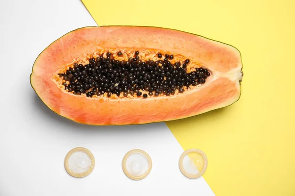 Composición plana con condones y papaya sobre fondo de color. Concepto erótico — Foto de Stock