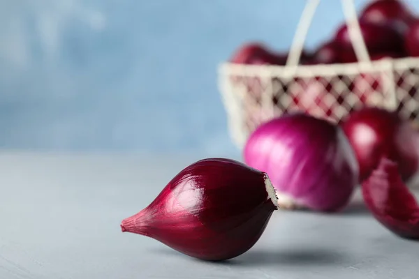 Cebolas vermelhas maduras frescas na mesa cinzenta — Fotografia de Stock